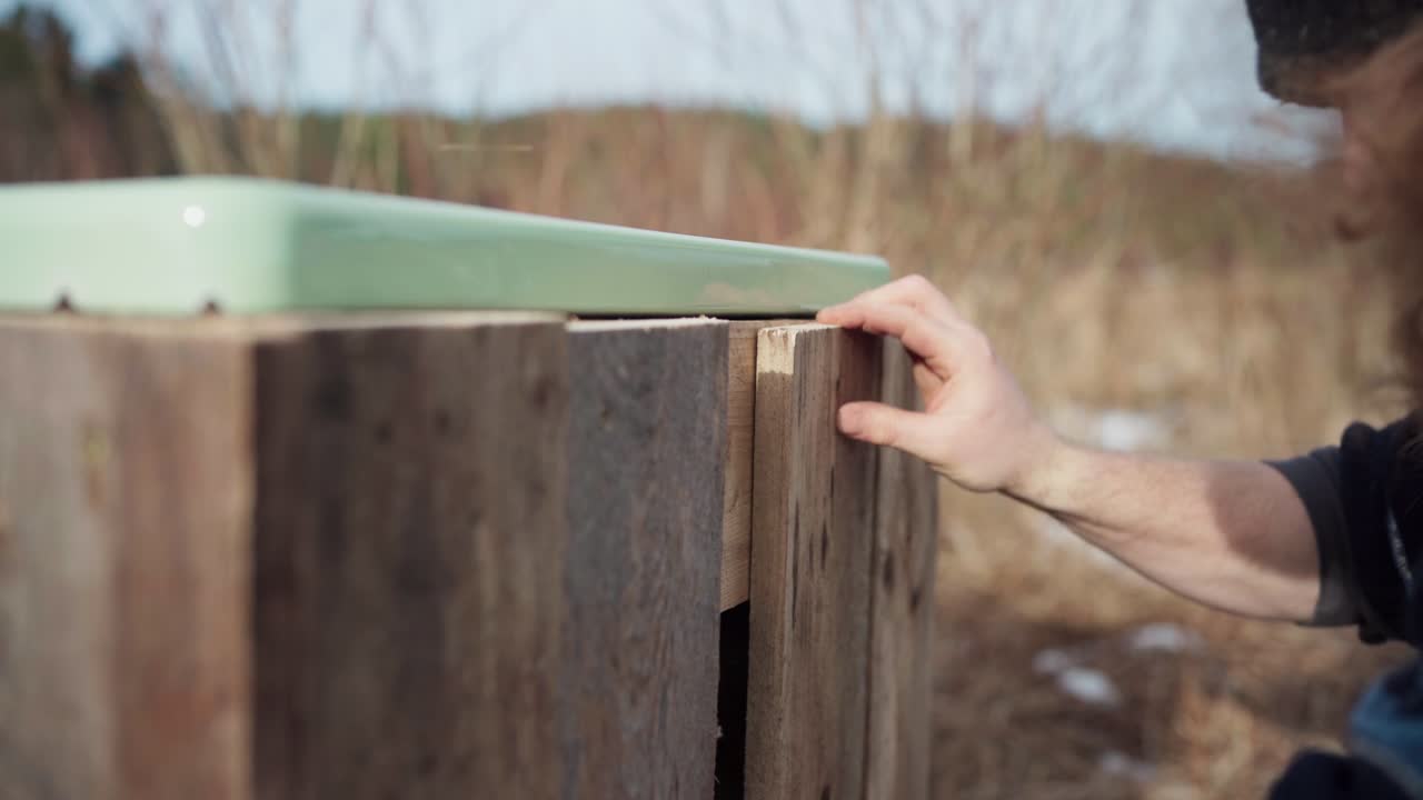 A Man Is Screwing Wood Plank Using Cordless Screwdriver