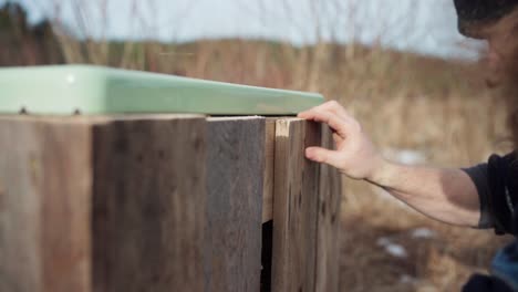 A Man Is Screwing Wood Plank Using Cordless Screwdriver