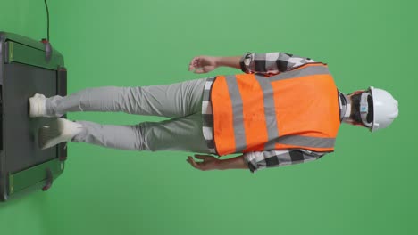 back view of full body asian male engineer with safety helmet and walking in the green screen background studio