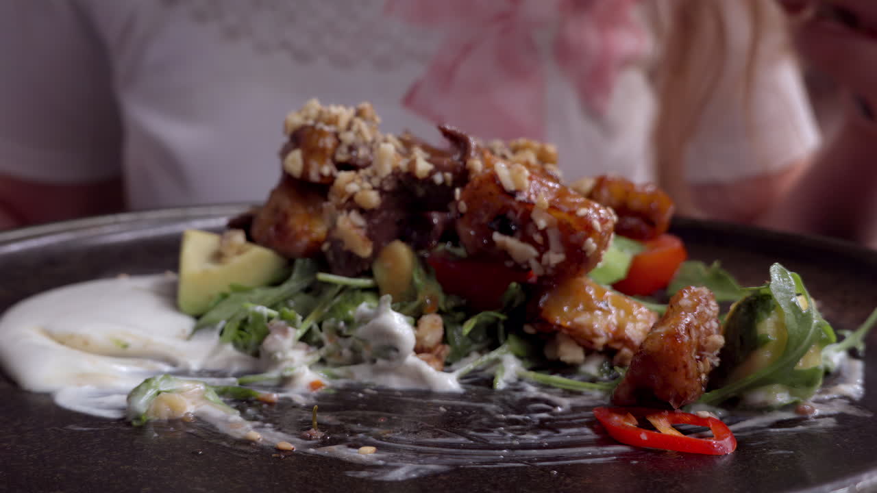 Woman eating a hot salad with veal at a restaurant