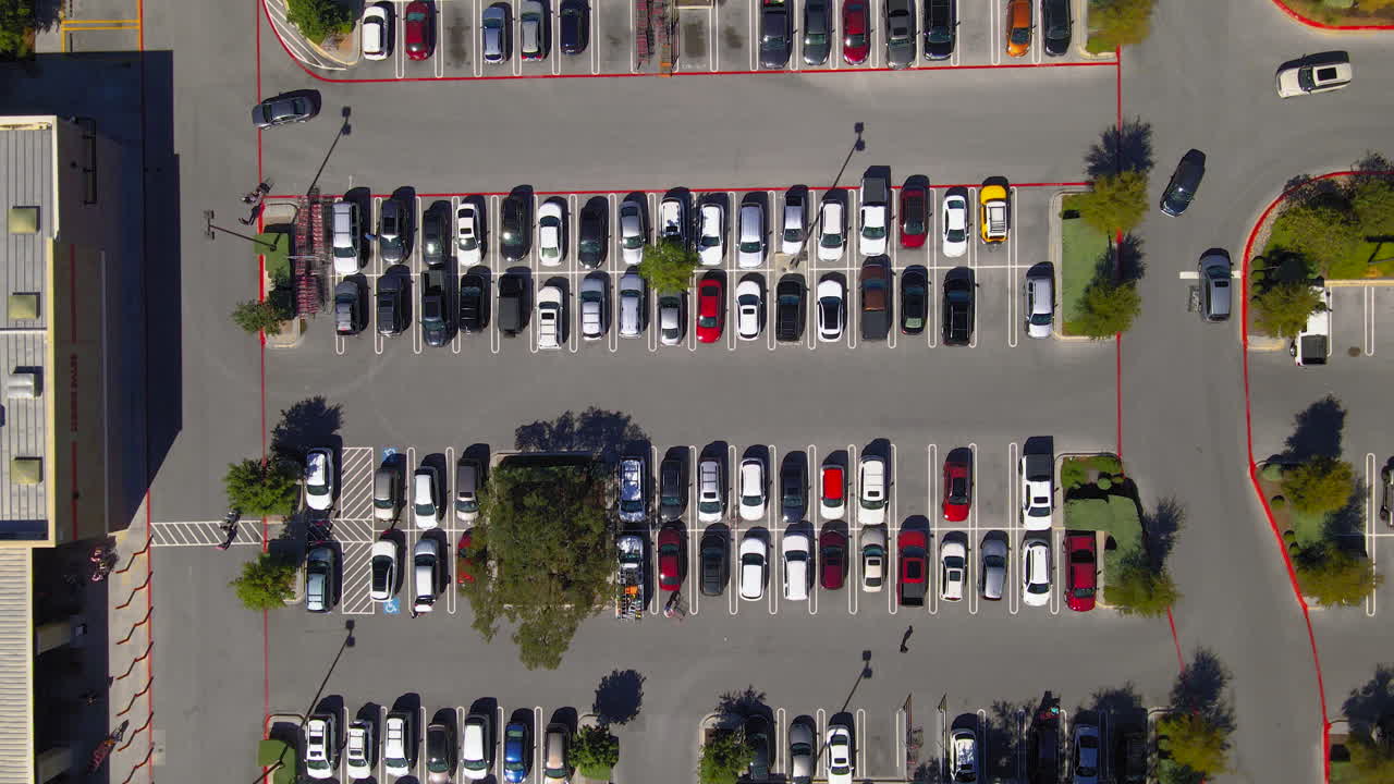 vista aérea de cima para baixo do estacionamento do shopping center, pessoas e carros no estacionamento em busca de vagas, drone 4k