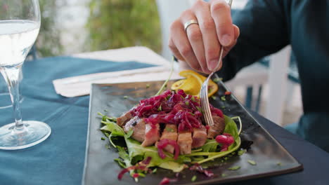 man starting to eat tuna and onion gourmet dish at the beach resort for lunch