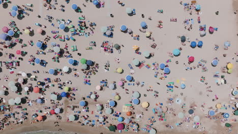 Imágenes-Aéreas-De-Arriba-Hacia-Abajo-Alejándose-De-Los-Turistas-En-La-Playa-Con-Una-Variedad-De-Colores-En-Bari,-Italia