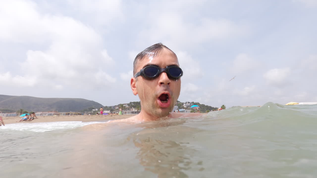 Man wearing swimming googles swimming in the sea