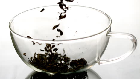 dried loose tea pouring into glass cup