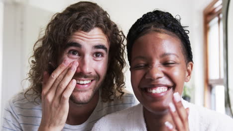 a young caucasian man and an african american woman are smiling at the camera