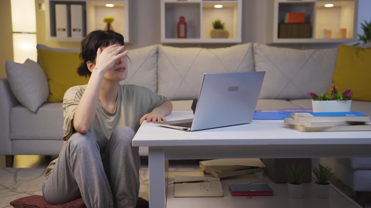 밤에 집에 있는 지친 젊은 여성. 무력한 얼굴 표정.