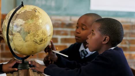 Schoolkids-using-globe-in-classroom-4k