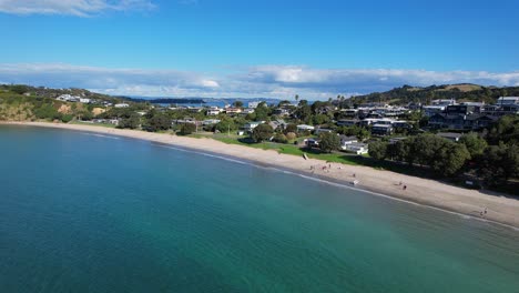 turquoise seascape of big oneroa beach in auckland, new zealand - aerial drone shot