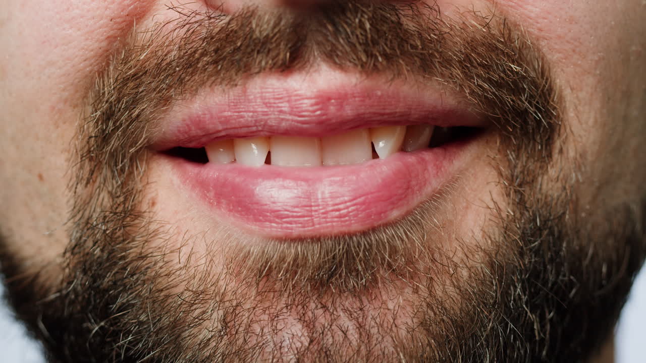 Close-up of a man's face with a beard and lips