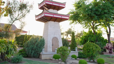 wide shot handheld, pagoda building from oriental countries in a beautiful green garden