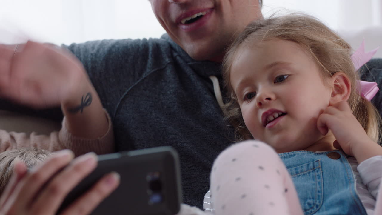 famiglia felice che chatta in video usando lo smartphone a casa madre e padre con i figli che chattano sul cellulare insieme 4k footage