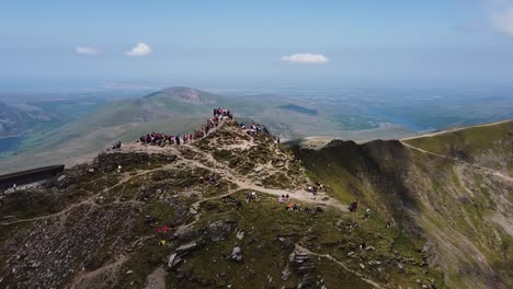 Verschneiter-Gipfel-An-Einem-Sonnigen-Tag-In-Wales-Mit-Leuten,-Die-In-Der-Schlange-Warten,-Um-Sich-Oben-Fotografieren-Zu-Lassen