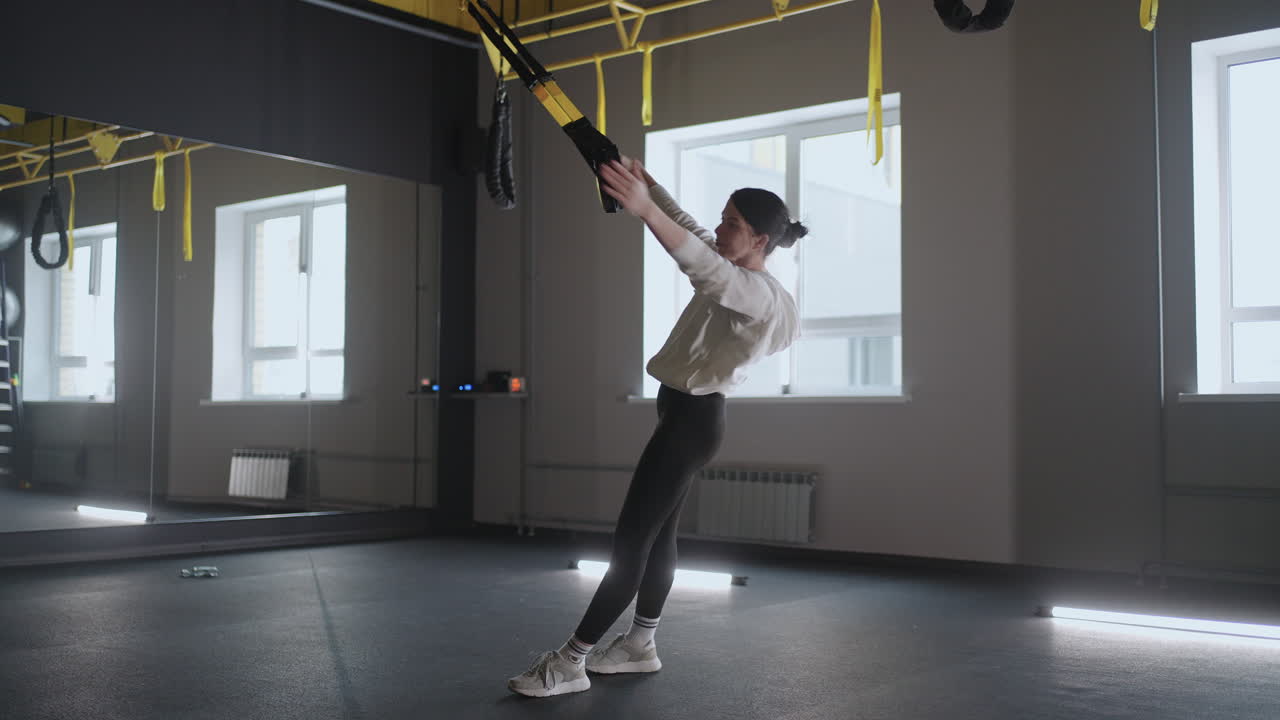 피트니스 체육관에서 trx 장비로 운동하는 여성 건강한 라이프 스타일 강하고 적합한 몸을 만드는 매력적인 여성 피트니스 체육관에서 피트니스 스트램으로 코어 abs 크로스피트 훈련을하는 여성