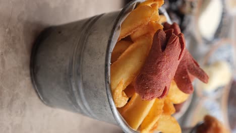 french fries and octopus sausages in a metal bucket