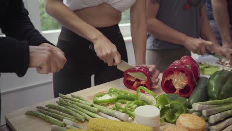 cropped shot of people chopping vegetables in kitchen