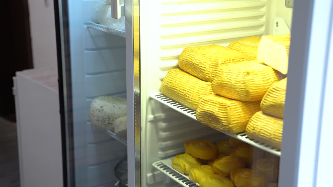 Refrigerador con muchas ruedas de queso artesanal de leche de vaca hecho a mano.
