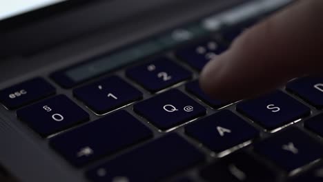 a close-up video of a finger pressing the q key on a laptop keyboard. the dark keys and shallow depth of field create a focused and professional atmosphere