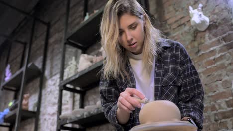 woman sculpting pottery in studio