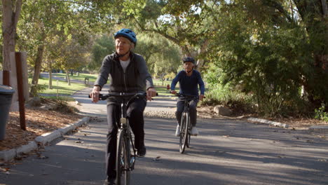 casal de idosos andando de bicicleta pelo parque em câmera lenta