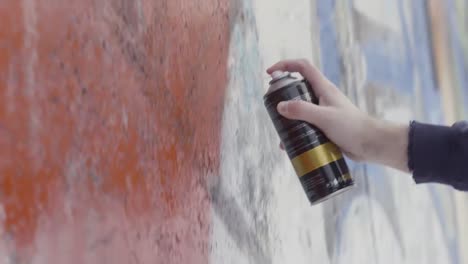 graffiti artist spray painting a wall