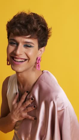 transgender person with pink clothes and make up smiling at the camera