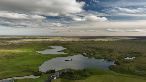 Wetlands-lakes-and-green-pasture-in-lava-field-Iceland-aerial-summer-day