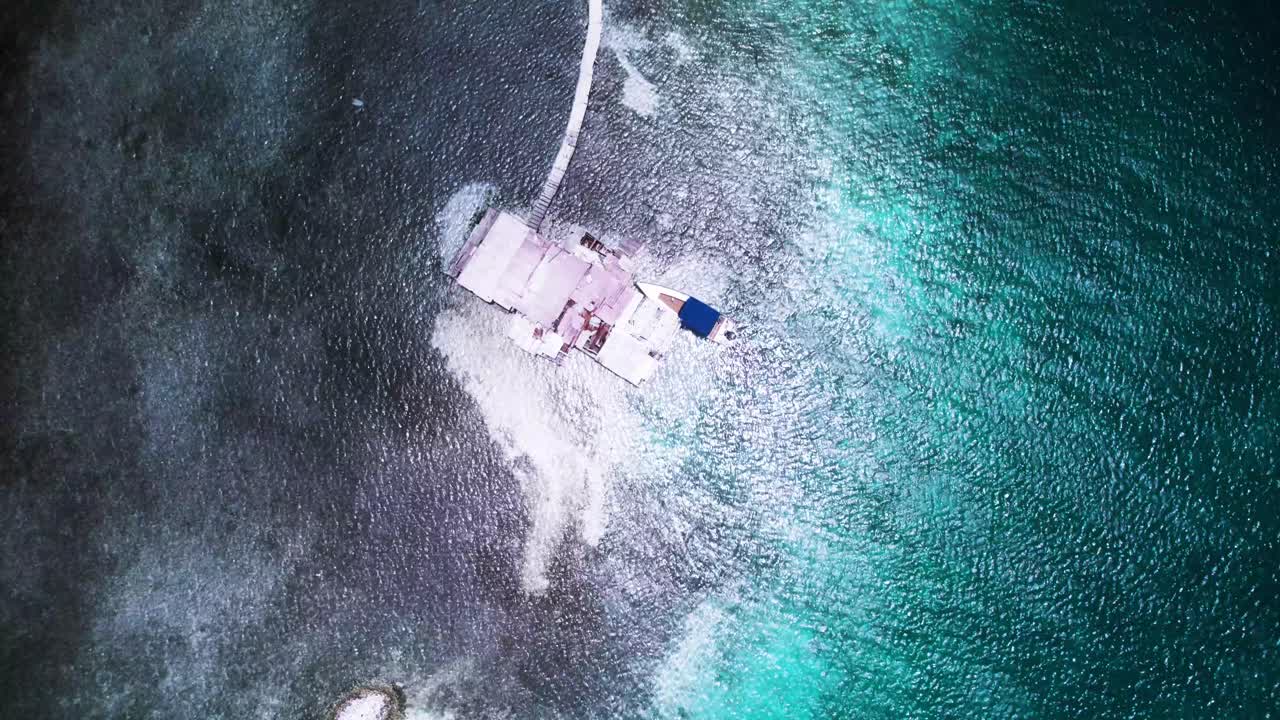 A palafito above turquoise waters in los roques, showing a stunning coastline, aerial view
