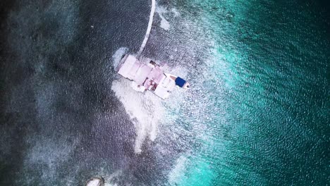 a palafito above turquoise waters in los roques, showing a stunning coastline, aerial view