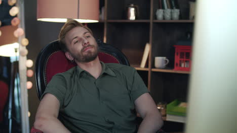 handsome man leaning back from computer. employee falling from broken chair