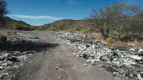 Garbage-Along-the-Desert-Roadside-in-Mulege,-Baja-California-Sur,-Mexico---Drone-Flying-Forward