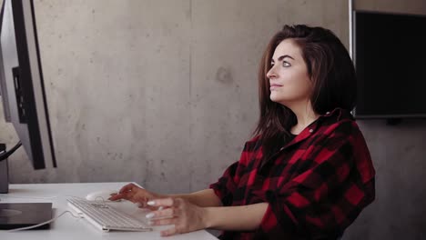 Young-attractive-girl-smiling-and-laughing-with-genuine-joy-while-typing-something-on-the-keyboard.