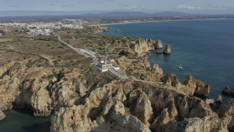 An-Einem-Schönen-Sonnigen-Tag-Fliegen-Wir-über-Die-Ponta-De-Piedade,-Während-Die-Wellen-Auf-Die-Klippen-Stürzen