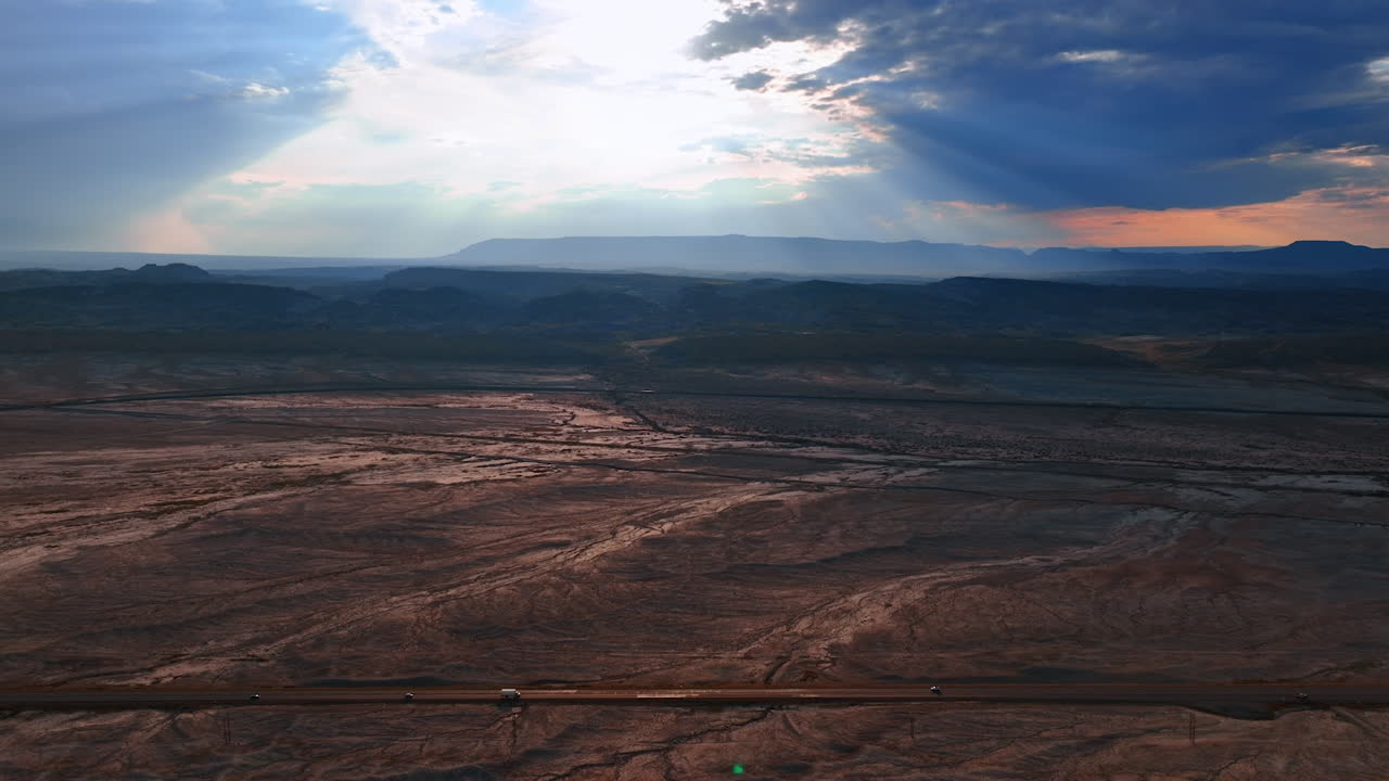 Drone aerial photo of the Utah desert valley at sunset with dramatic light rays through clouds