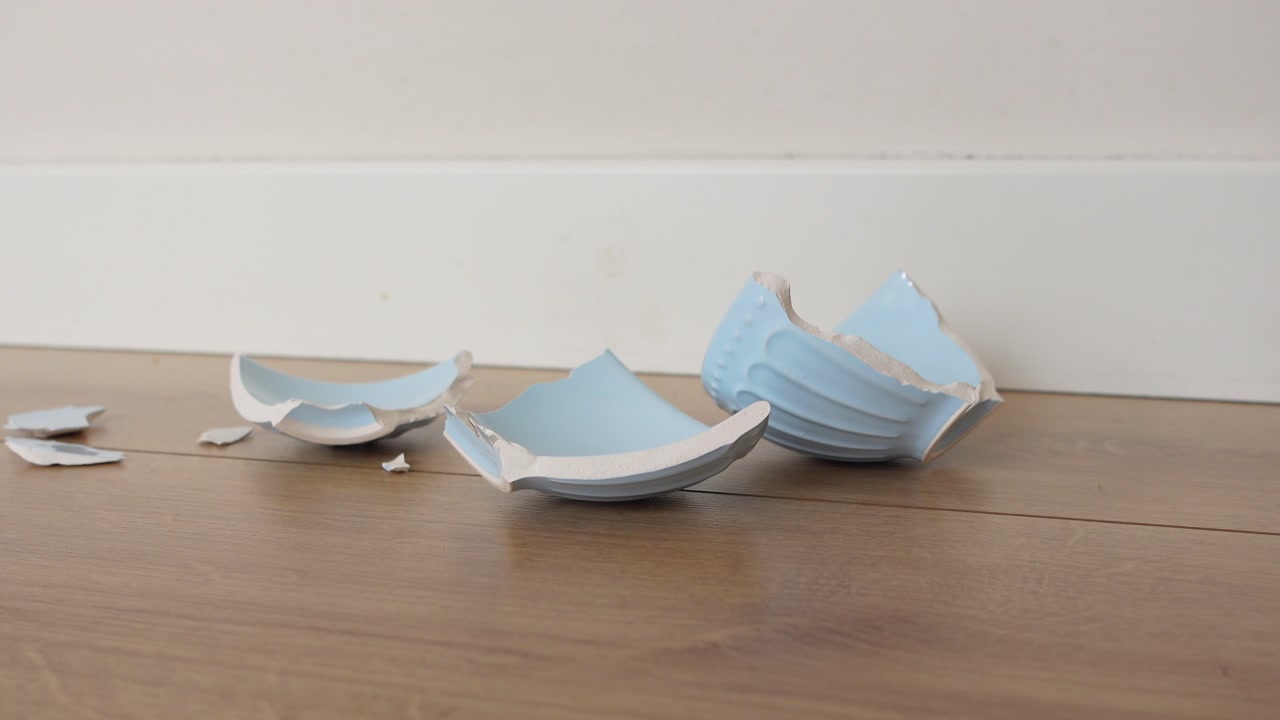 Broken Light Blue Ceramic Pot Pieces on Wooden Floor