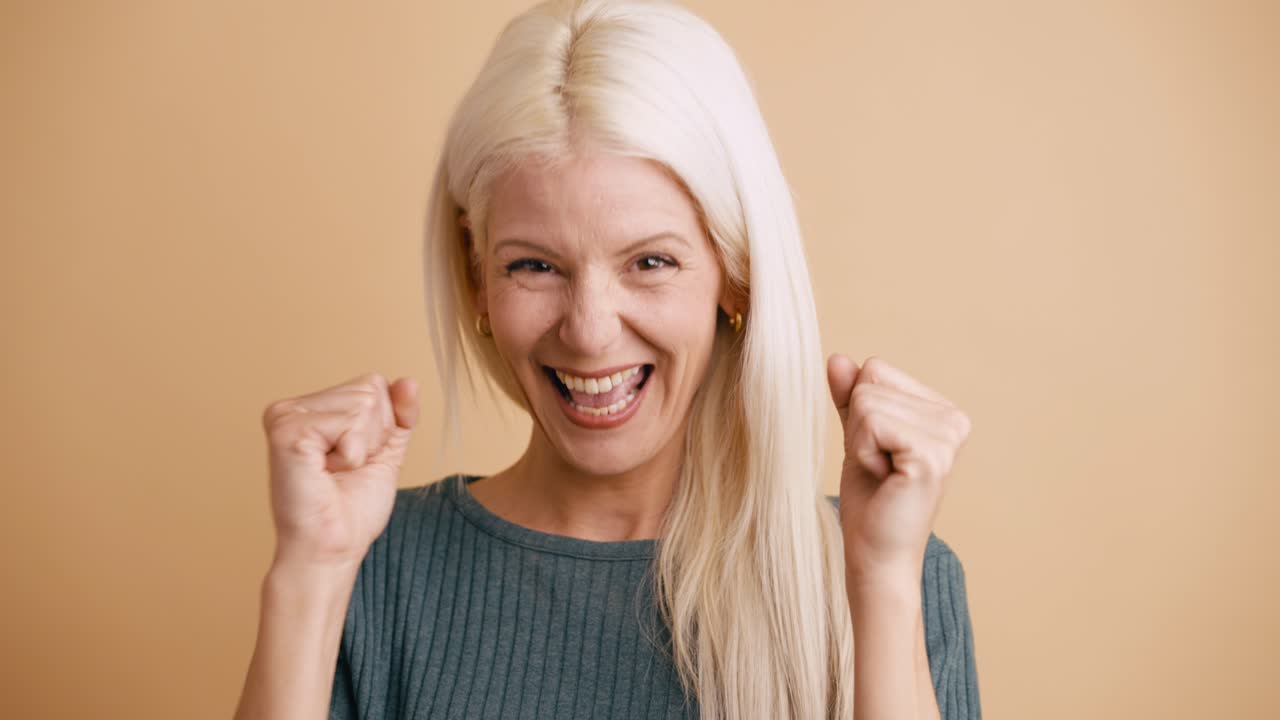 Donna bionda gioiosa che festeggia con un sorriso trionfante