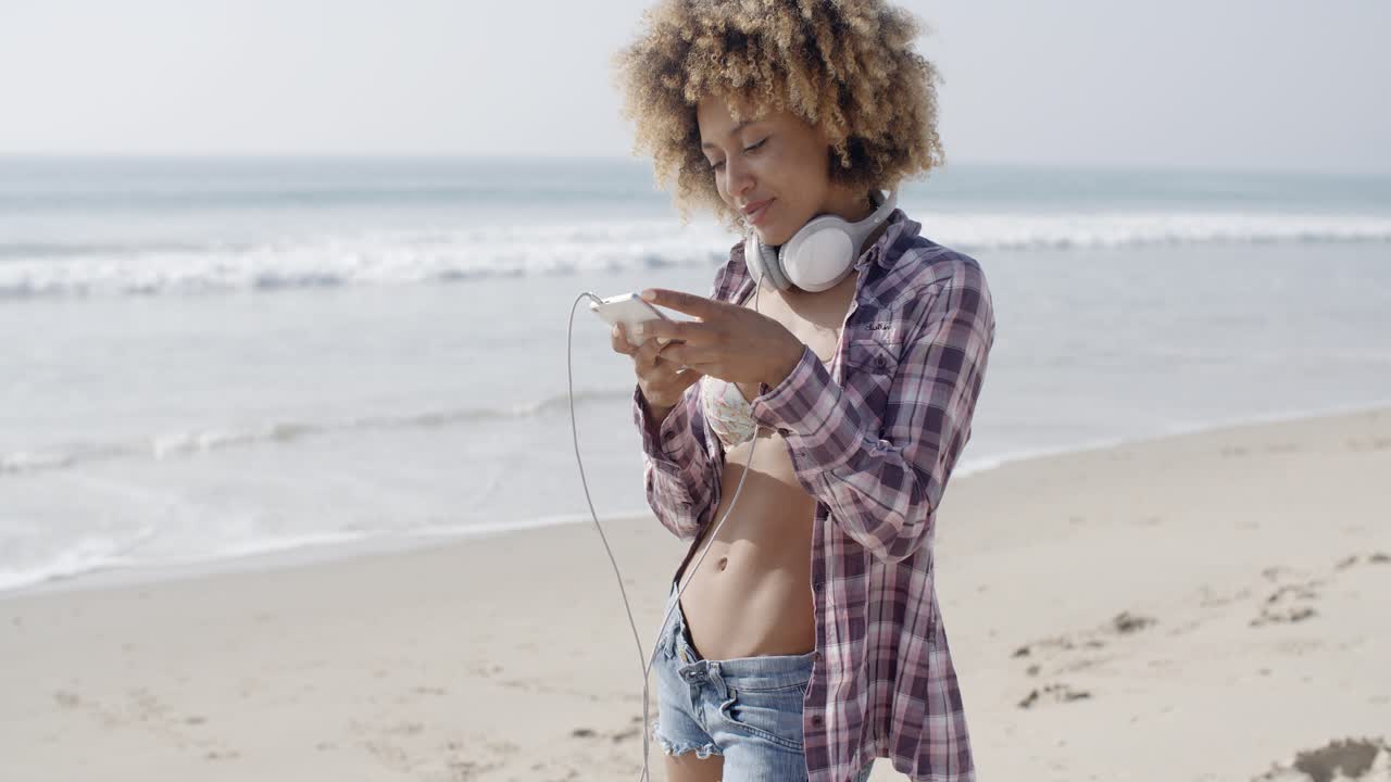 mujer enviando mensajes de texto en la playa