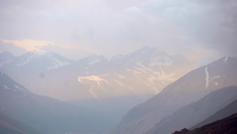 dramatic snow capped mountains in the hunza valley in northern pakistan at sunset.