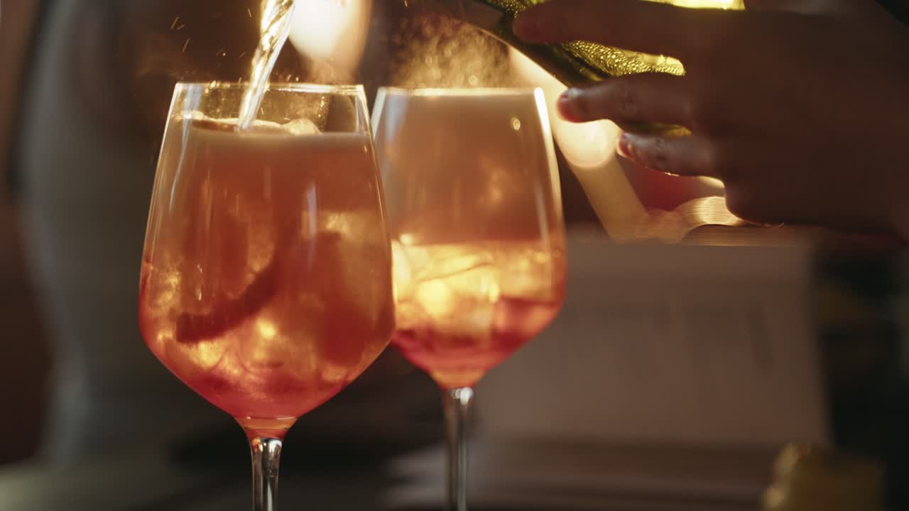 2 Drinks of Aperol getting filled with proseco during golden hour closeup from drinks