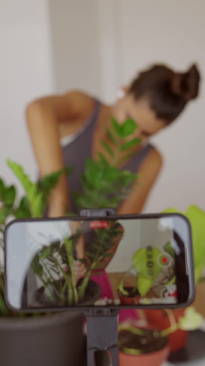 Donna che registra consigli sulla cura delle piante con lo smartphone