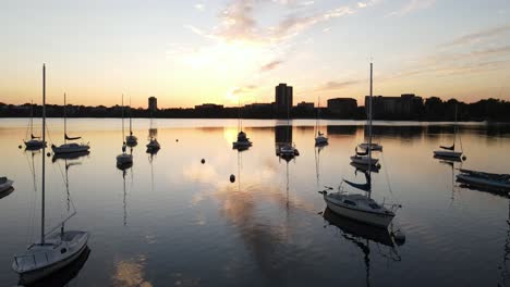 aerial-view-of-boats-at-the-lake-during-sunset,-golden-hour-in-minneapolis,-minnesota-during-summer-time