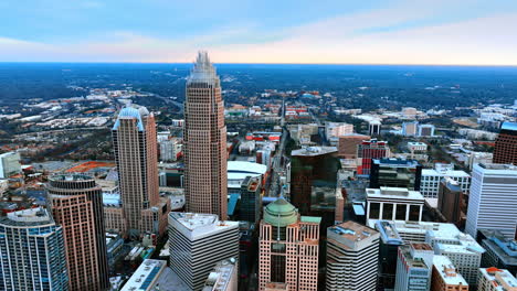 drone approaching the group of high-rise buildings built close to each other in the city downtown. view of north carolina, usa from aerial perspective