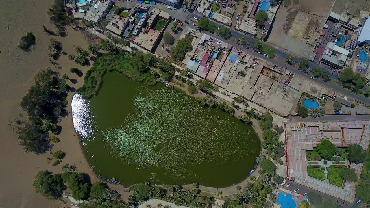 oasis del desierto de huacachina desde una vista aérea de arriba hacia abajo con vistas al lago desde arriba