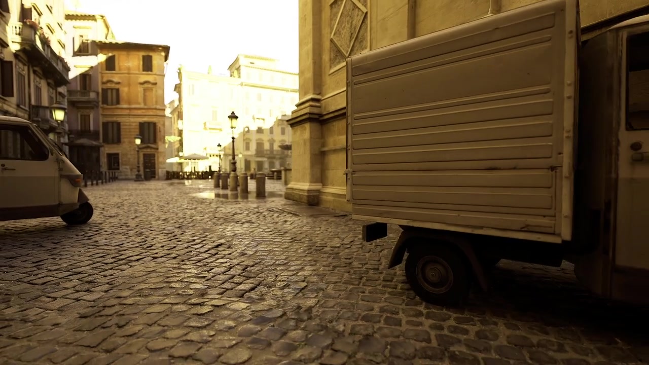 Wide cobbled area directs attention to sunlit square with urban life beyond
