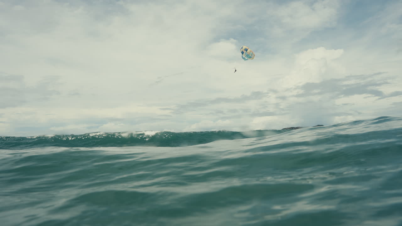 Parasailing over ocean waves