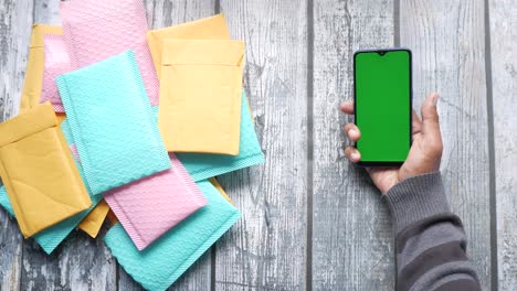 Green-and-pink--paper-bubble-envelope-on-table