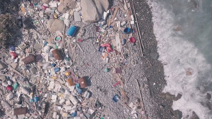 Problemi ambientali mostrati da una spiaggia coperta di plastica e rifiuti a Hong Kong. Vista aerea statica da drone.