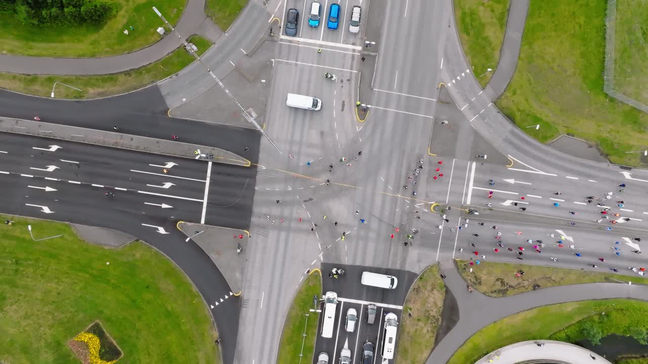 марафонцы пересекают закрытый перекресток улицы, сверху вниз