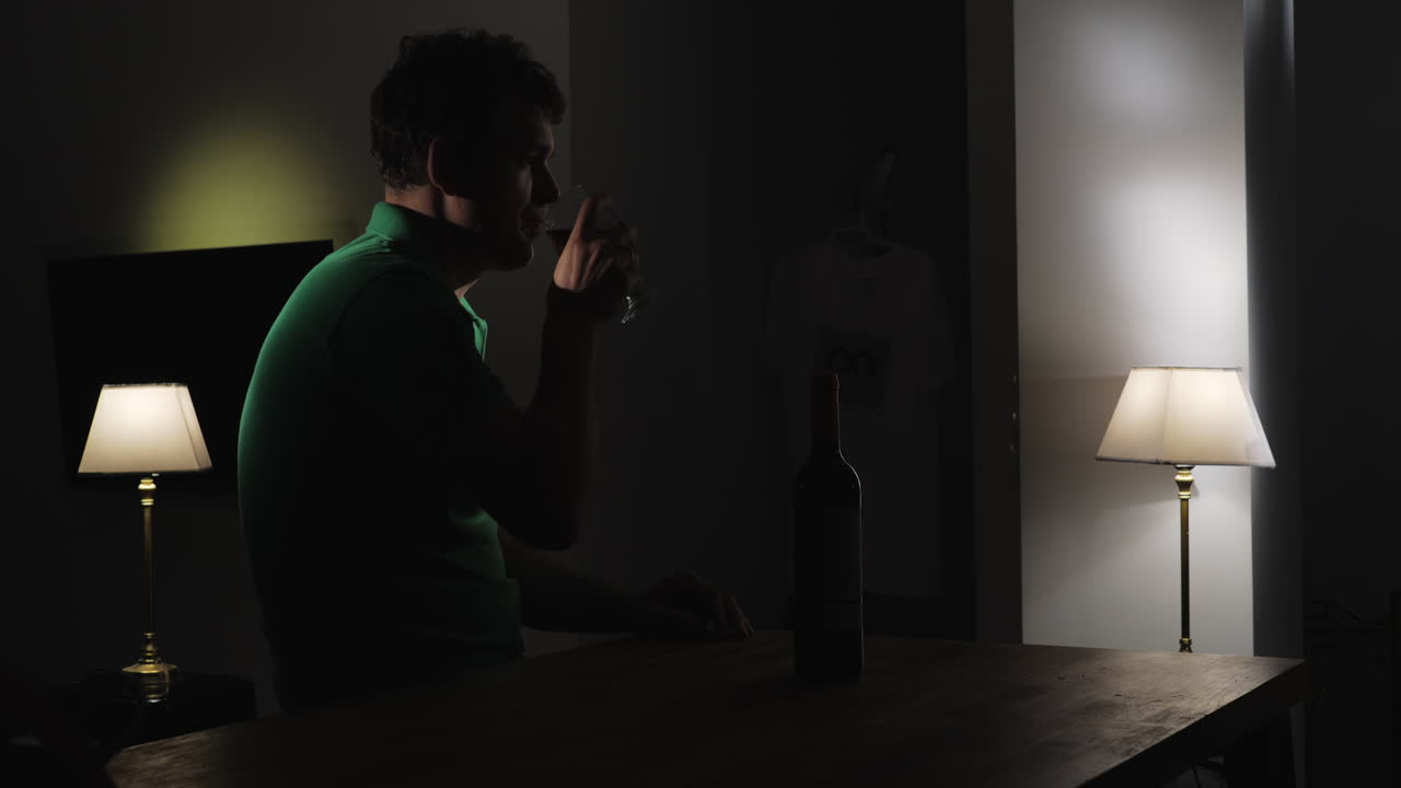 어 속에서 혼자 와인을 마시는 화가 난 남자