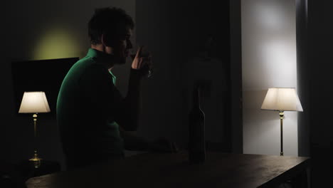 Upset-man-drinking-wine-alone-in-the-darkness